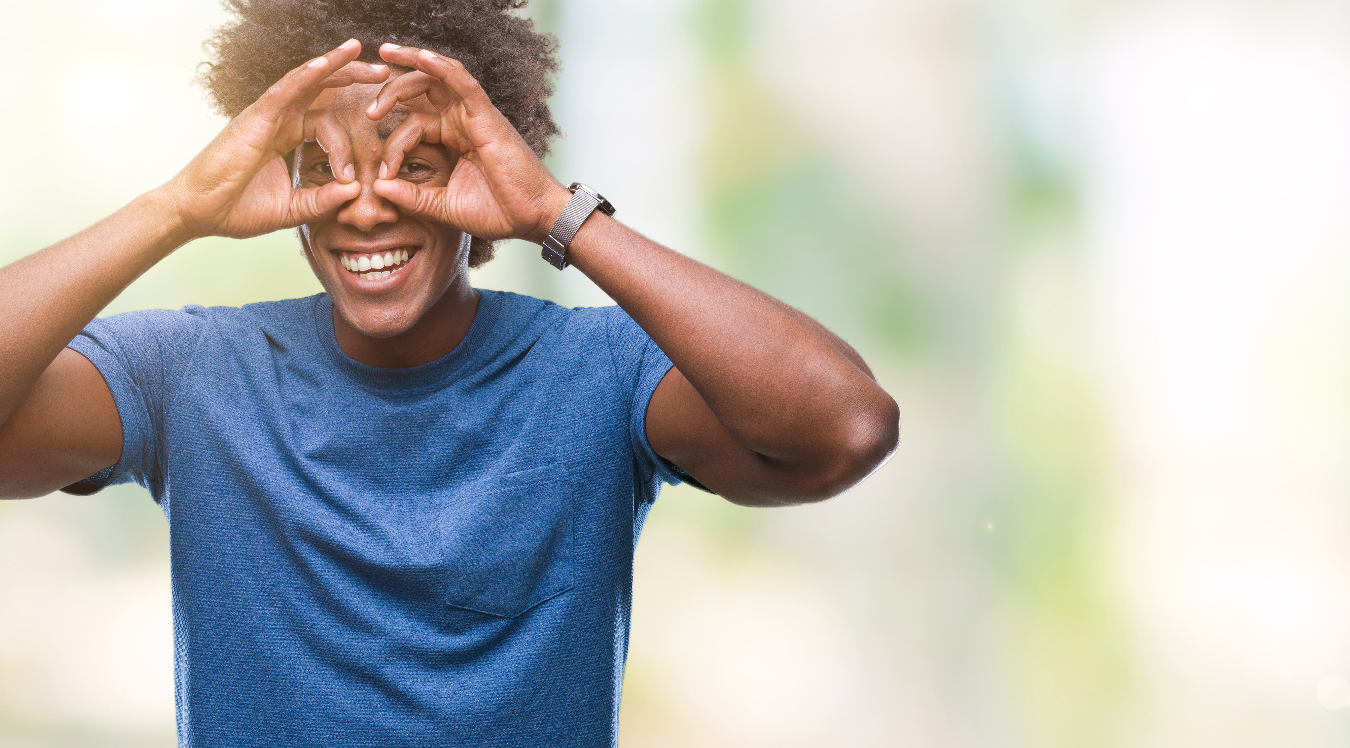 Man making a glasses shape with his hands over his eyes