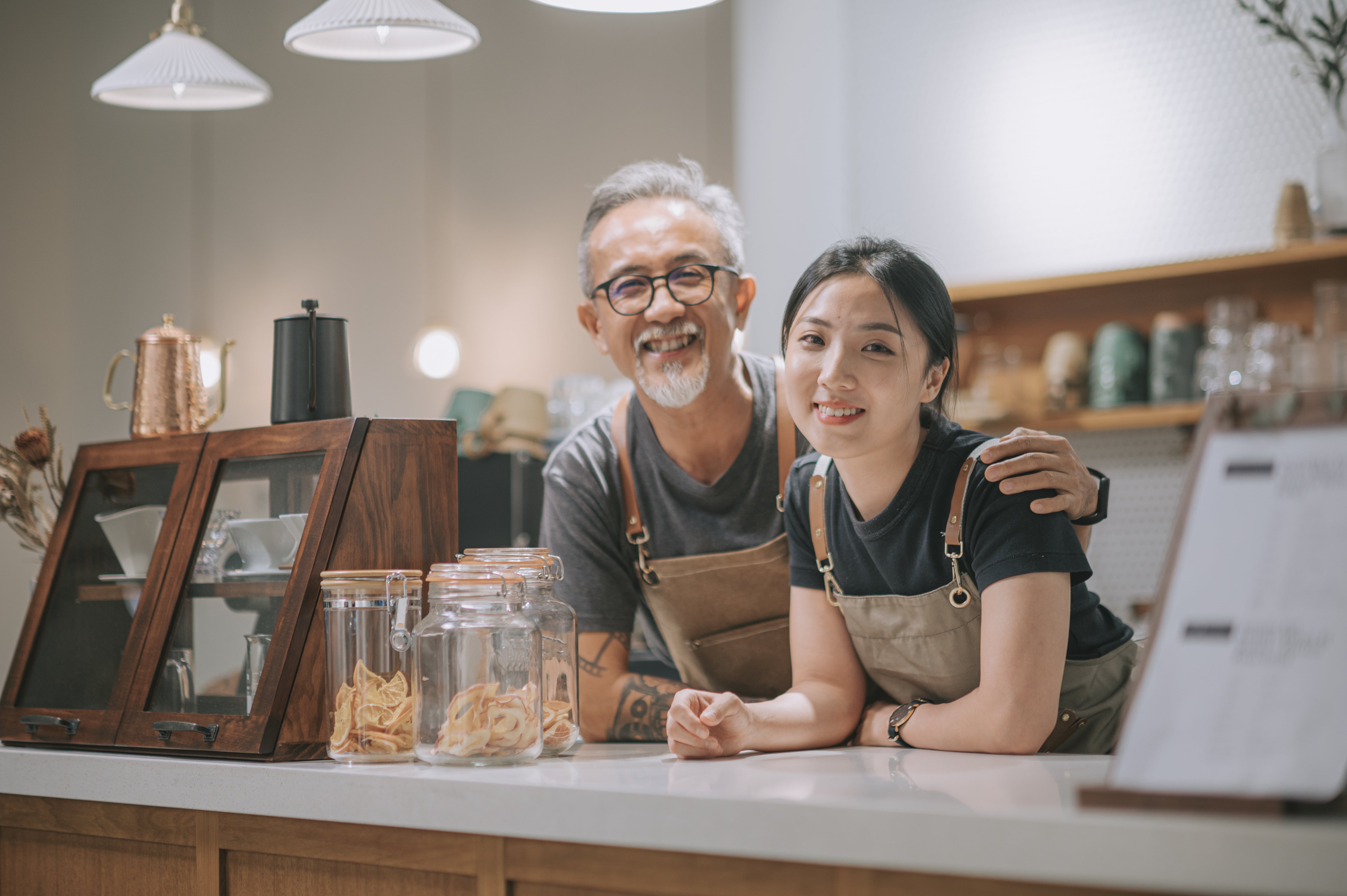 Man and woman coffee shop employees standing behind counter